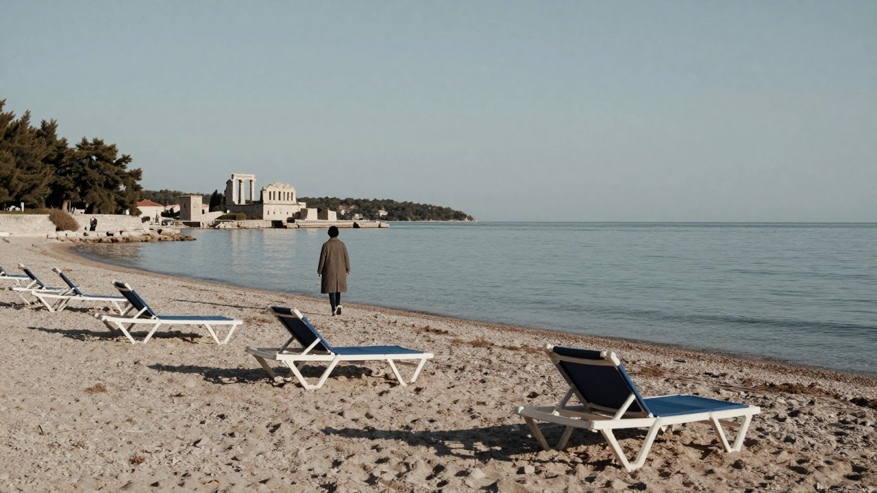 Опустевший пляж на Хваре в декабре с одиноким путешественником и каменными руинами на фоне.